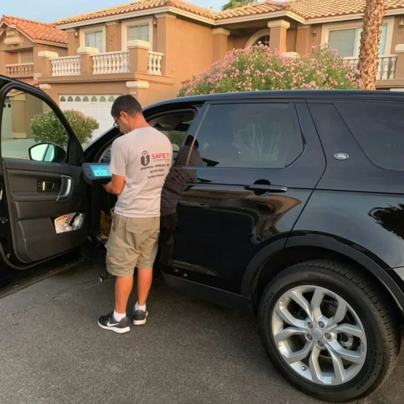 Hombre abriendo la puerta de una camioneta negra estacionada frente a una casa