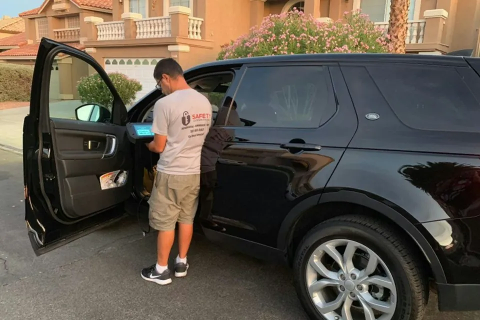 Hombre abriendo la puerta de una camioneta negra estacionada frente a una casa